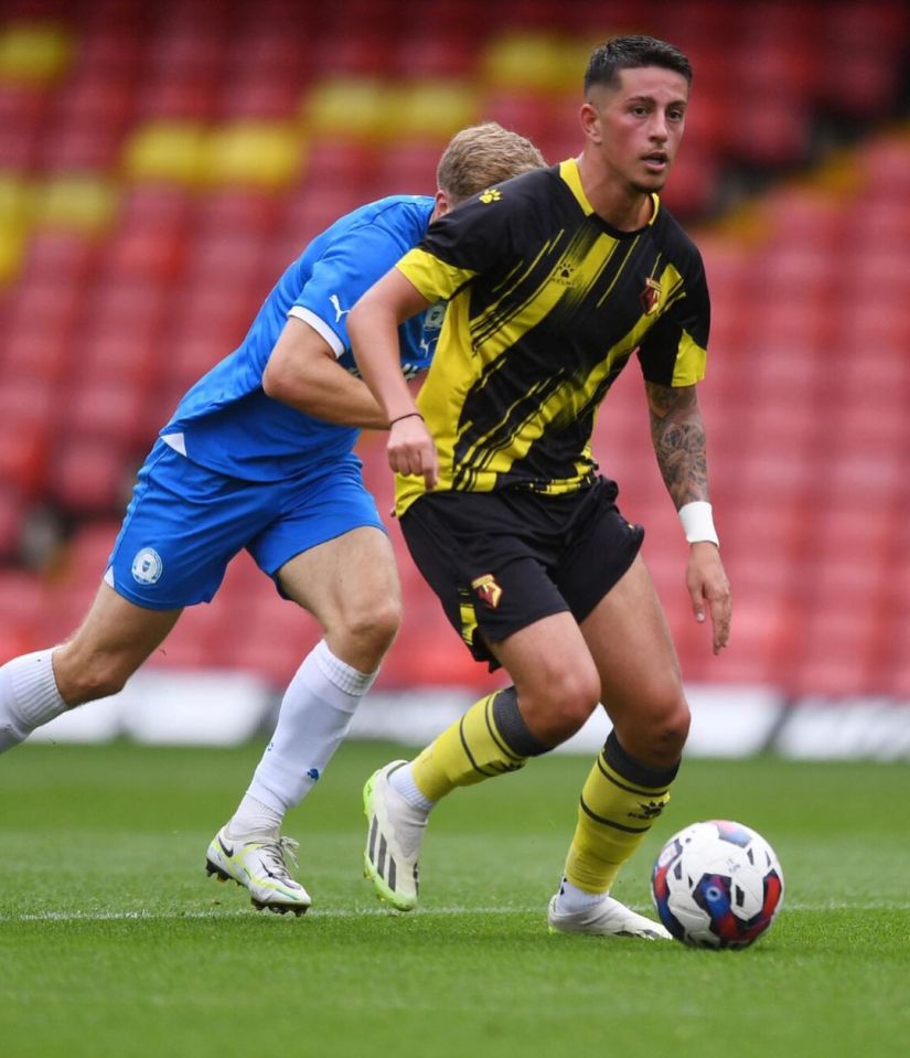 a soccer player wearing a yellow and black jersey with the word watford on it