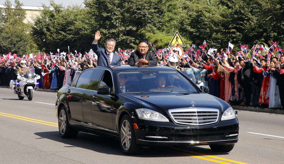 South Korean President Moon Jae-in, left, and North Korean leader Kim Jong-un ride in a car parade in September 2018 in Pyongyang