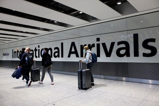 people walking in front of a sign that says international arrivals