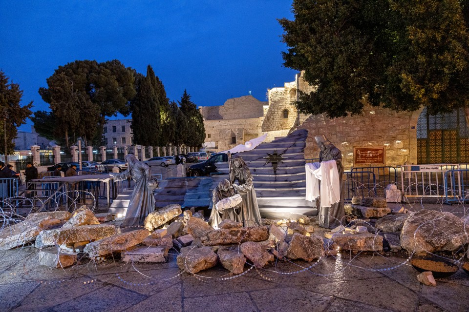 A nativity scene in Manger Square decorated with rubble and razor wire