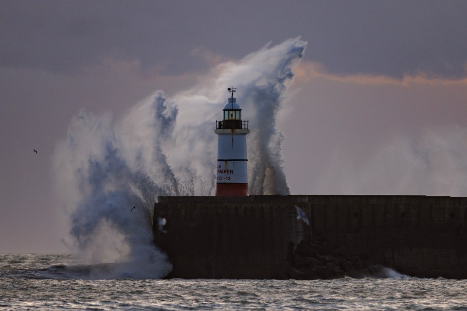 Waves crash over Newhaven lighthouse yesterday