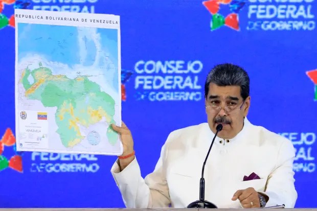 Nicolás Maduro holding up a map of the region showing Guyana Essequibo under Venezuelan control