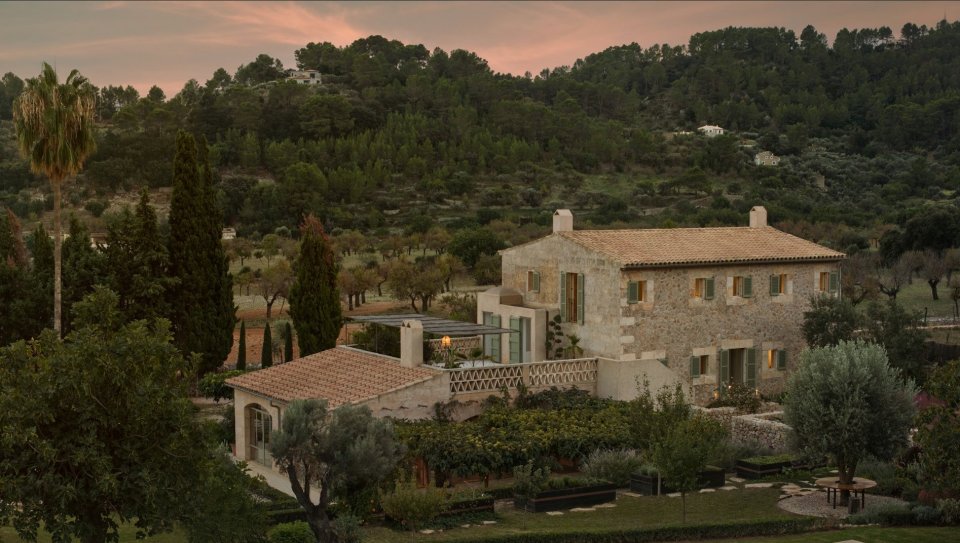 a large stone house sits in the middle of a forest