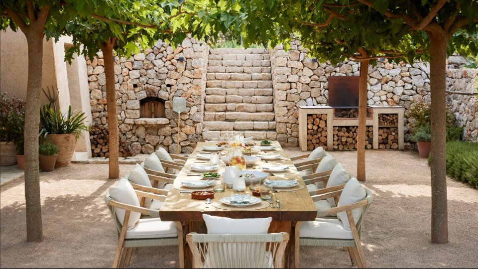 a dining area with a long wooden table and chairs