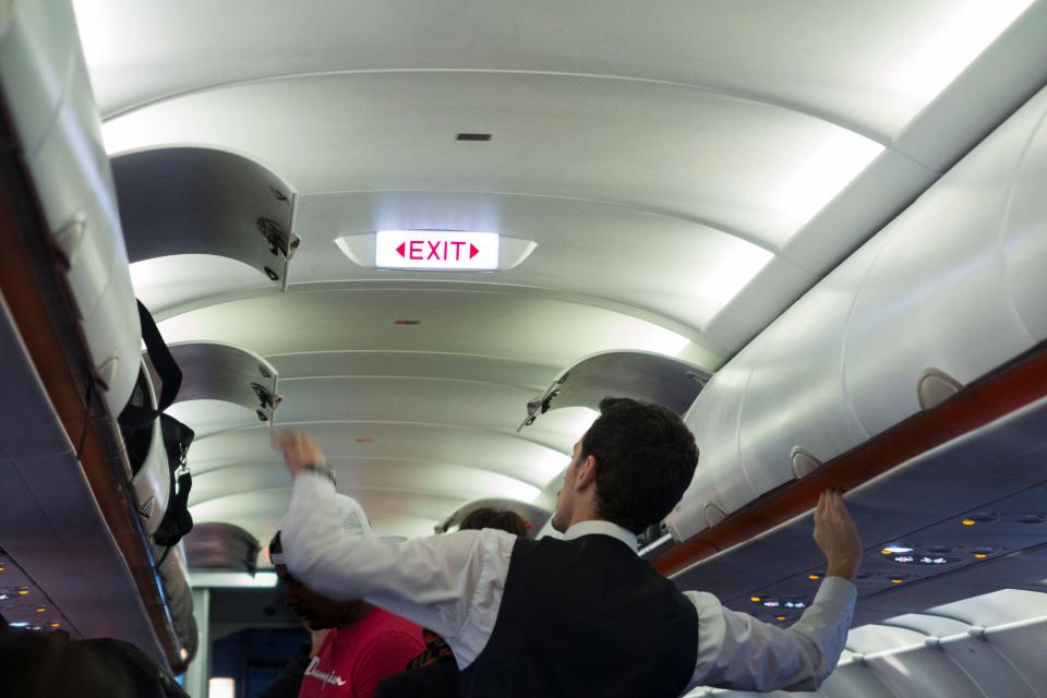 The handrail runs along the bottom of the overhead compartments