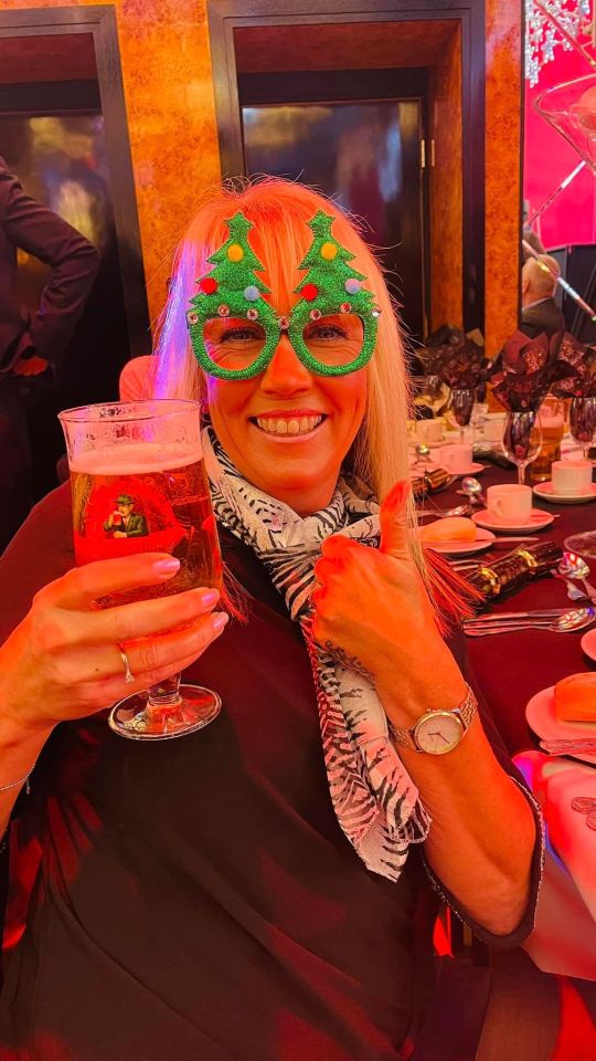 An Aslef reveller in festive glasses holds a pint