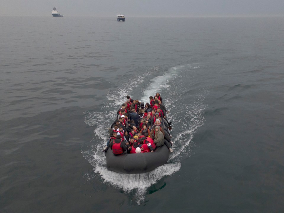 CORRECTED VERSION: THE ENGLISH CHANNEL, ENGLAND - AUGUST 24: In this aerial view, A boat carrying around 50 migrants drifts into English waters after being escorted by a French emergency tug, the Abeille Normandie (L) and the MCS Taku, a British vessel used to collect discarded dinghies (R), from the French coastline on August 24, 2023 The English Channel, England. Most of the small boats are collected on the border by UK Border Force vessels and brought into Dover port, after french naval ships accompany them to the border. Another boat then collects the small rubber crafts and loads them to be taken to a UK border Force facility. Over 100,000 migrants have crossed the Channel from France to England on small boats since the UK began publicly recording the arrivals in 2018. (Photo by Dan Kitwood/Getty Images)