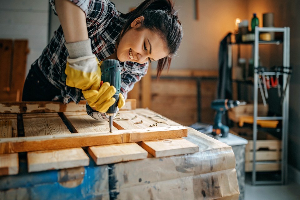 Woman screwing screws in lath to make table