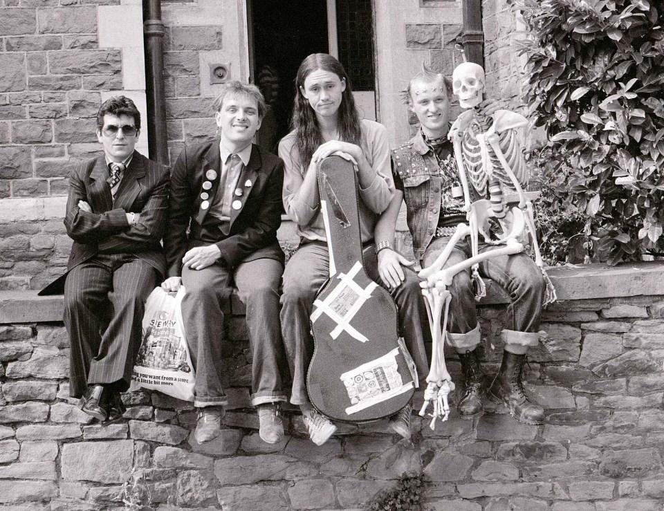 The main cast of Nigel, Mayall, Adrian Edmondson and Christopher Ryan sat in front of the house