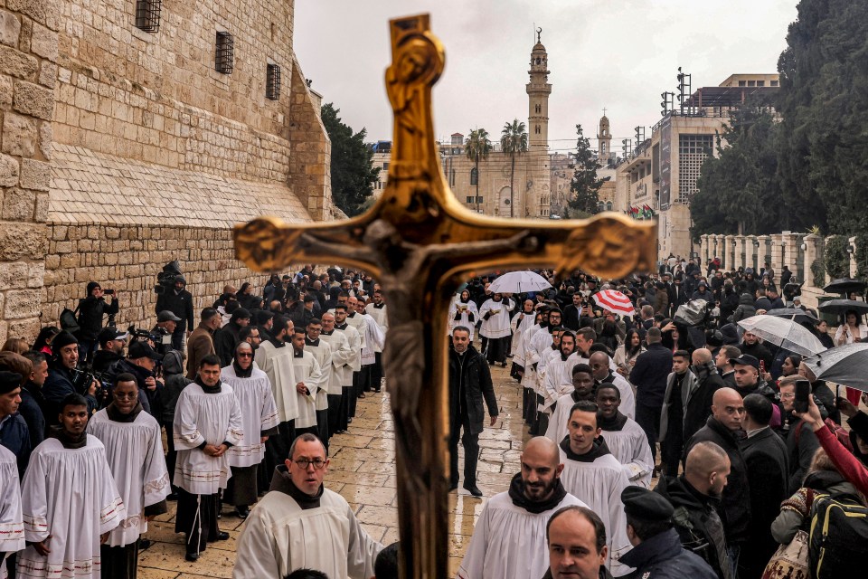 Religious officials solemnly gather in Bethlehem in the rain