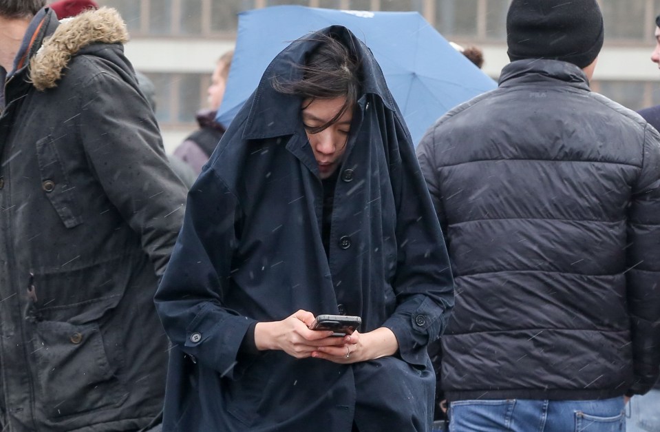 Brits sheltered from the rain and wind on Westminster Bridge in London today