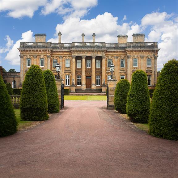 a large building with a red driveway leading to it