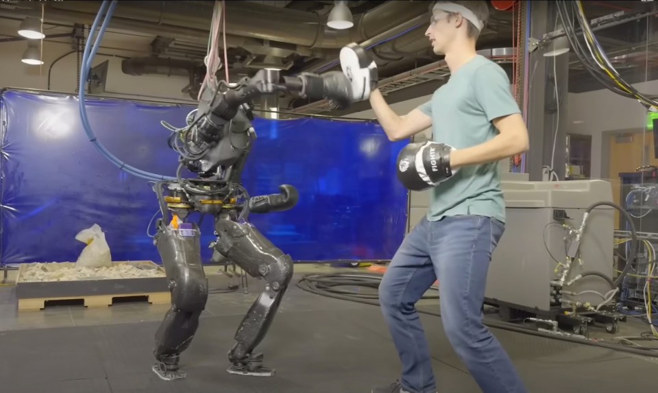 Video shows a boxing robot throw a punch against a human opponent in a match