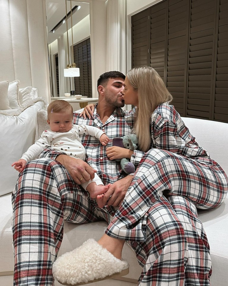 She kisses her fiance Tommy Fury as he holds their daughter Bambi