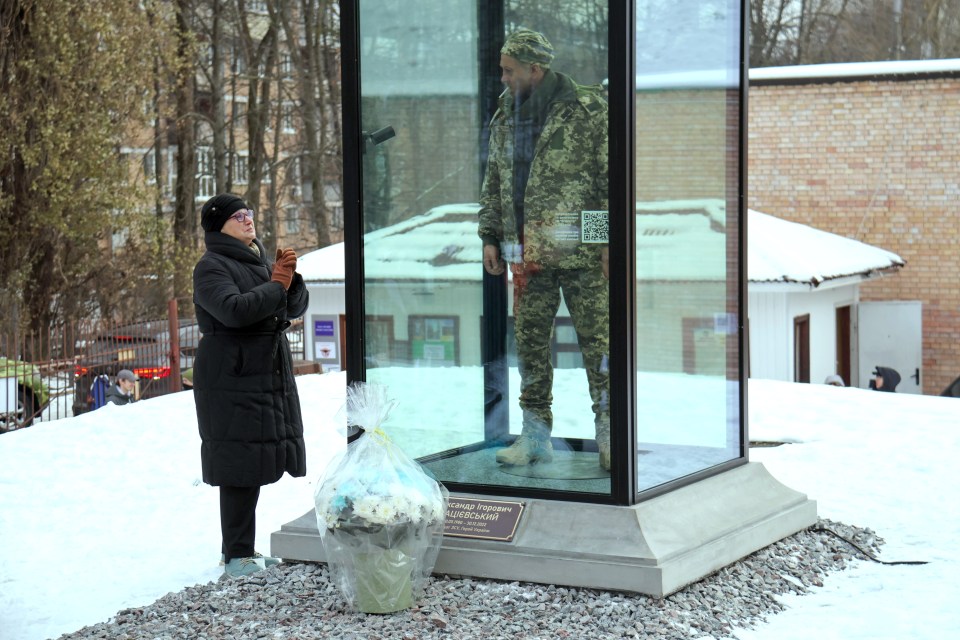 Paraska Demchuk, 68, gazes at the lifelike monument depicting her war hero son — executed by Russians after defiantly declaring 'Glory to Ukraine'