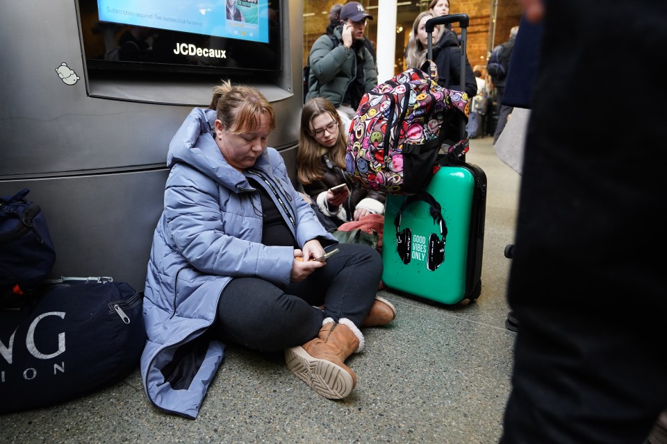 Passengers huddled on the station floor waiting to find out if they can still travel