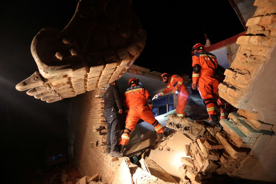 Rescue workers search through rubble in the village of Kangdiao