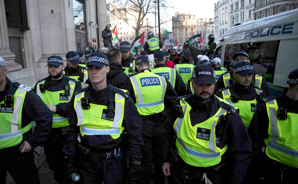 Police detain a protester during the march in London