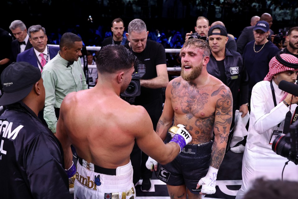 a boxer wearing a tnt glove talks to another boxer