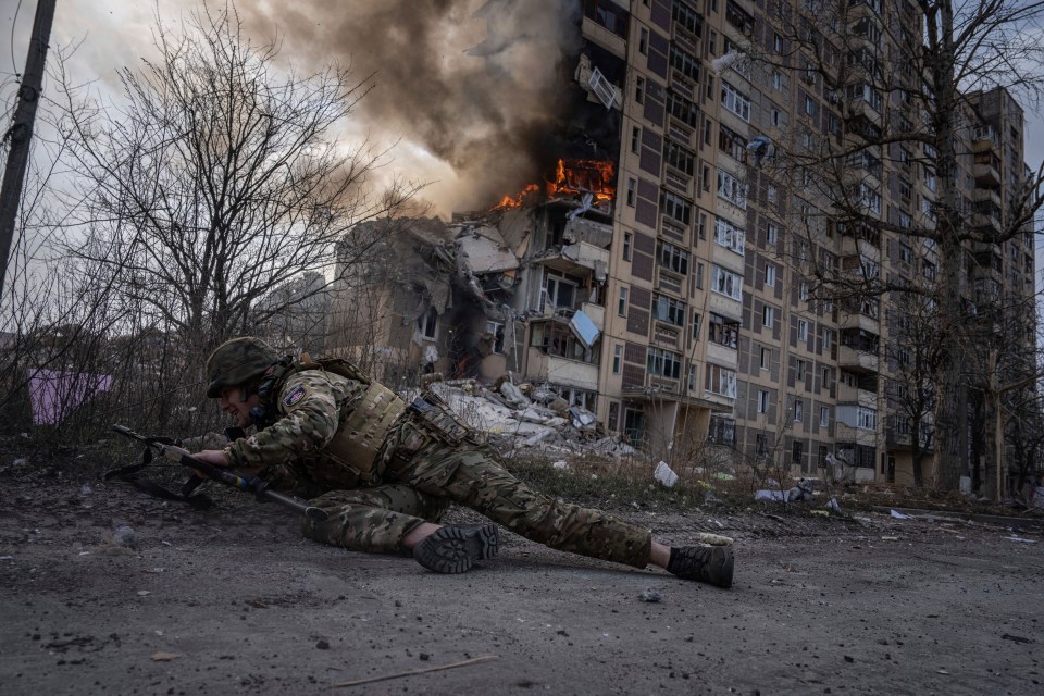 A Ukrainian soldier takes cover