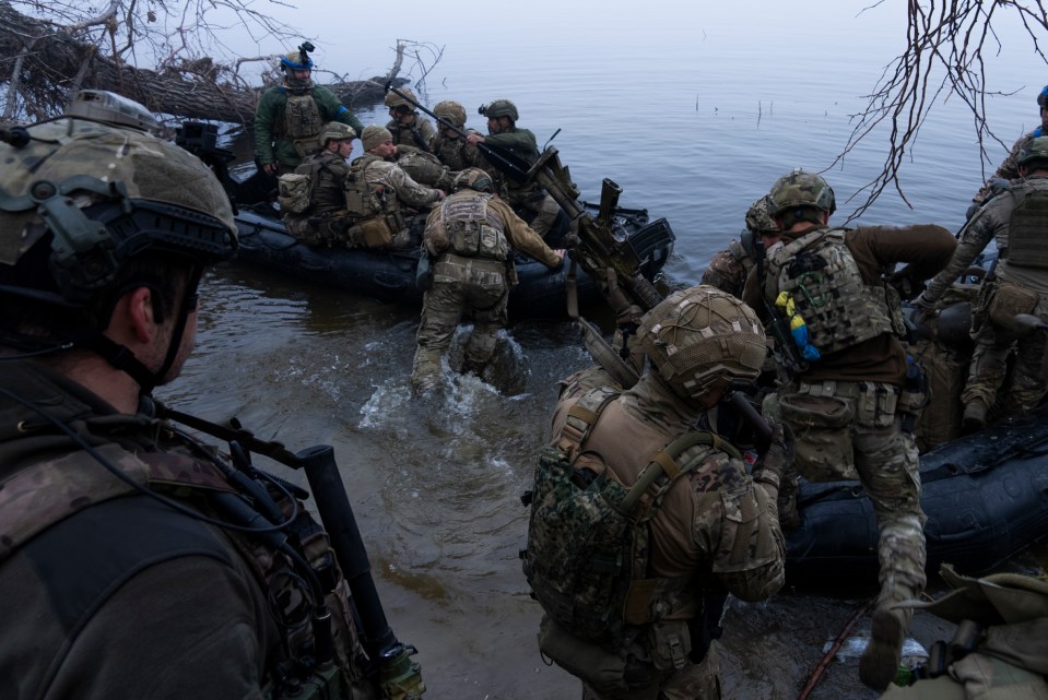 Ukrainian servicemen board a boat on the shore of Dnipro river at the frontline near Kherson