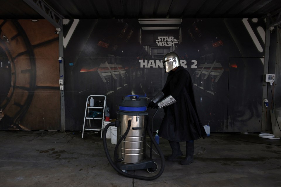 A worker dressed as a ‘Star Wars’ character pushes a vacuum cleaner