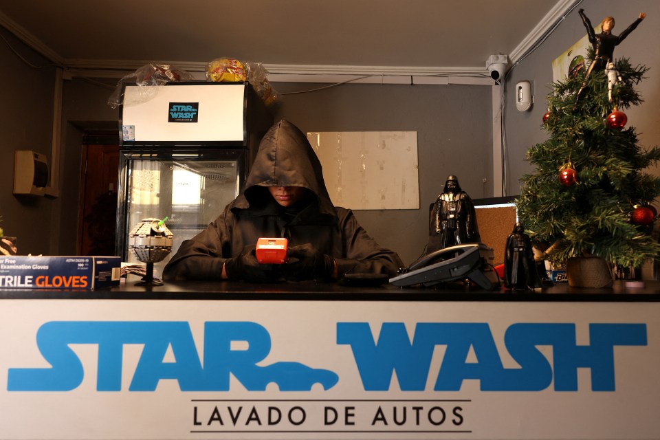 A worker uses a payment machine at the themed car cleaning service 'Star Wash’