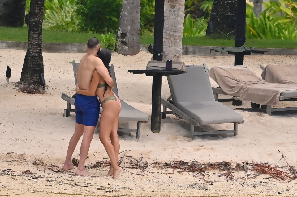 The couple embrace on the beach