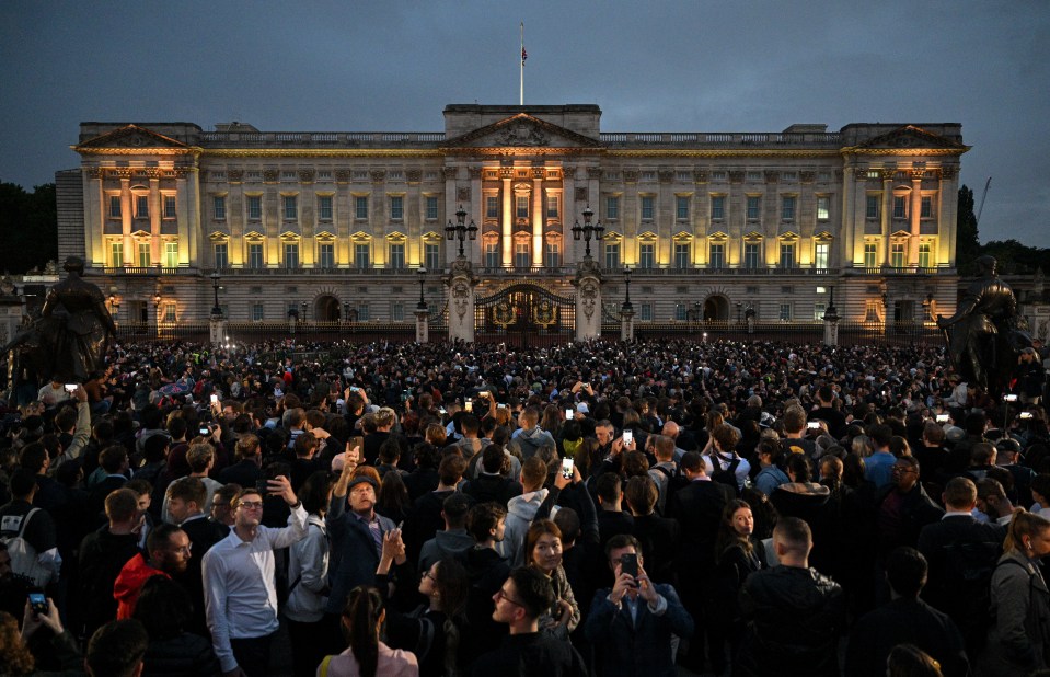 The Union flag flies half mast as people gathered at Buckingham Palace after the Queen's death