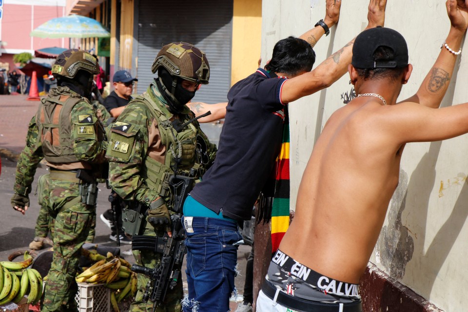 Members of the Armed Forces frisk men during an operation to protect civil security in Quito, on January 10, 2024