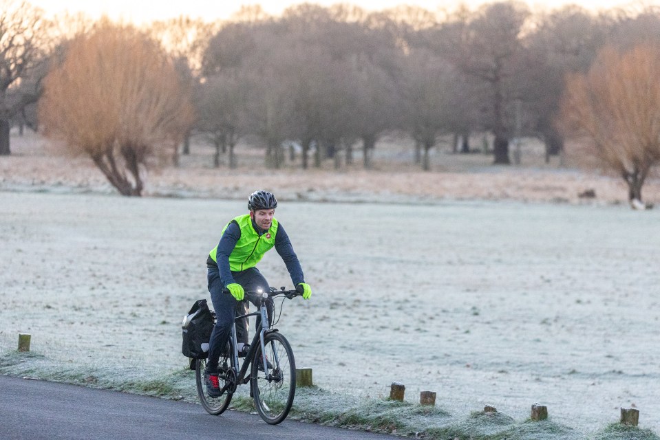 A cyclist braves the frosty conditions in Richmond Park, South West London, this morning