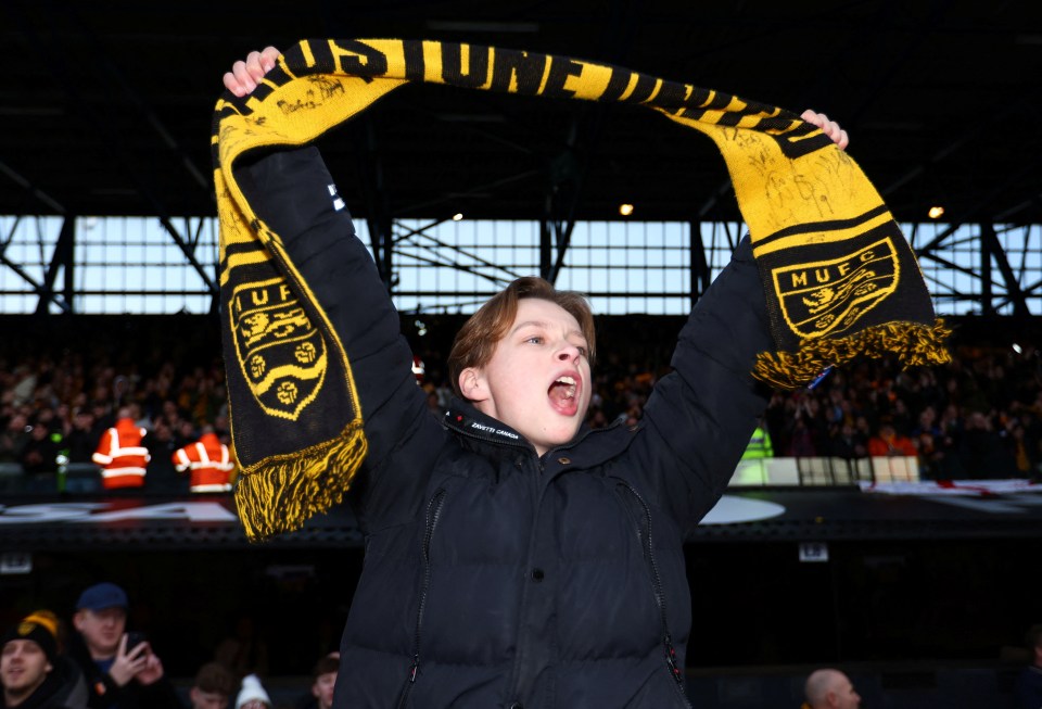 A Maidstone United fan celebrates after the match