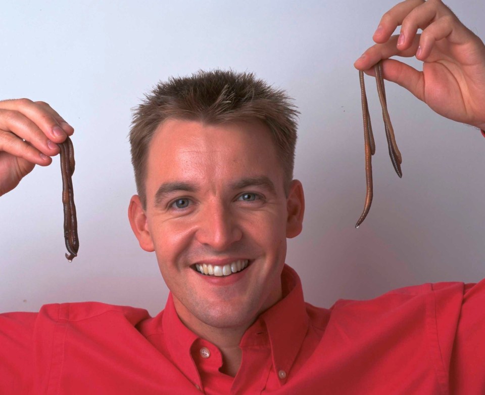 Radio and television presenter Simeon Courtie holding up earthworms, circa 1997