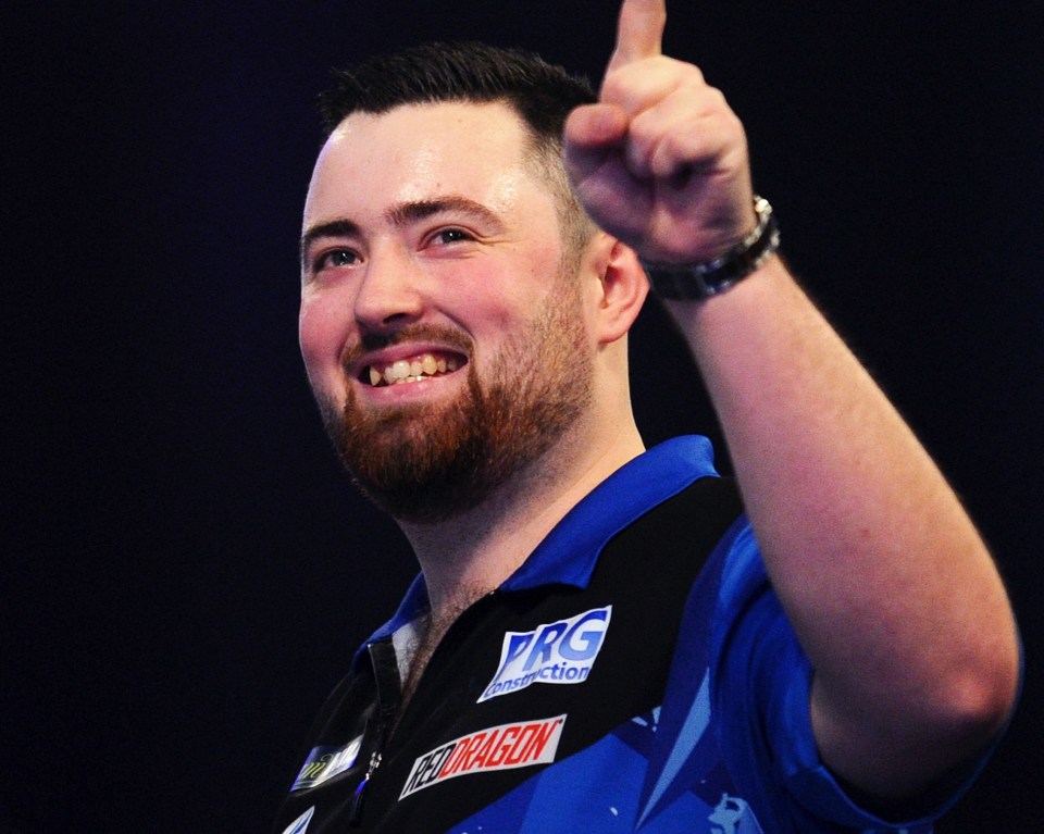 Luke Humphries celebrates winning a darts match.