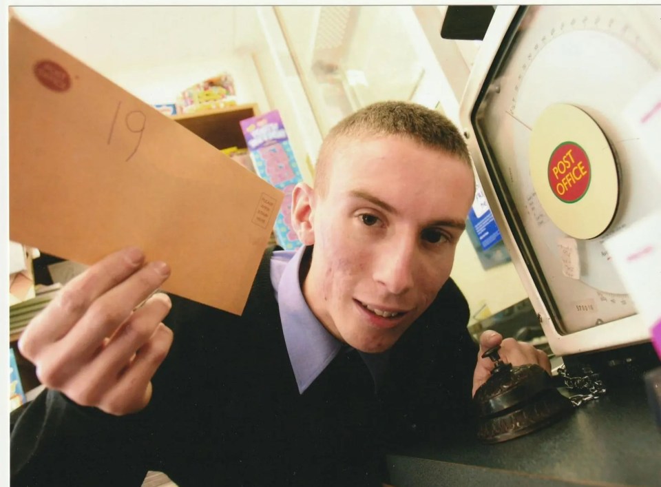 Christopher pictured a year after landing his dream job running a post office