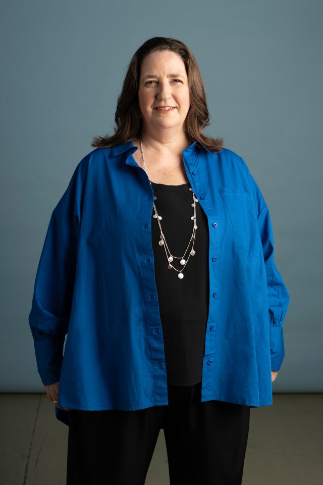 a woman wearing a blue shirt and a silver necklace