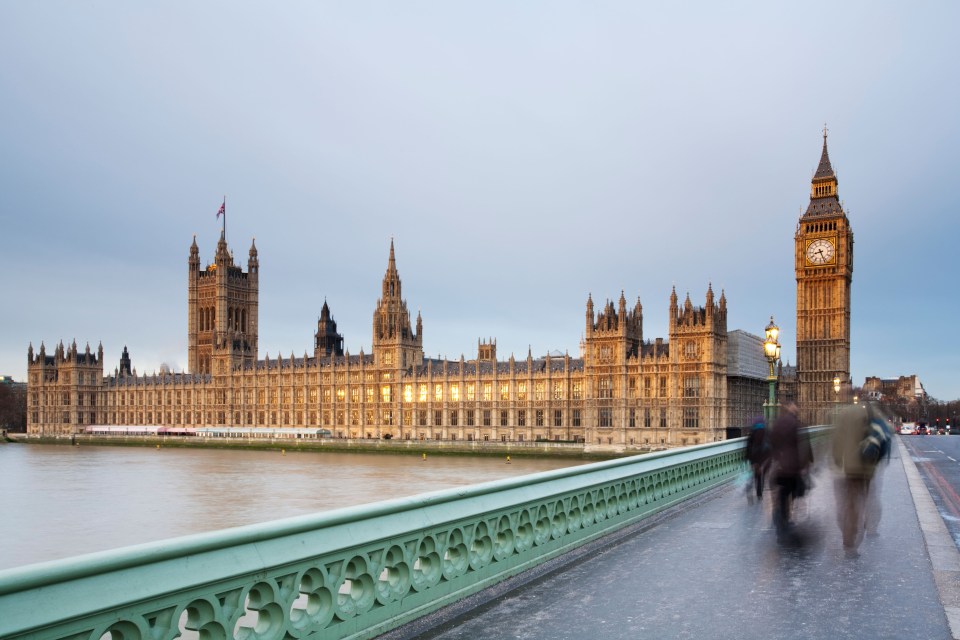 BXNP7M Early morning commuters crossing Westminster Bridge on a winter's dawn looking towards the Houses of Parliament, London, Uk