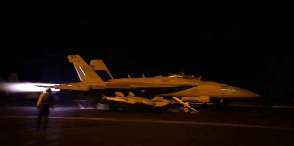 A jet fires up before soaring off the runway on the overnight mission