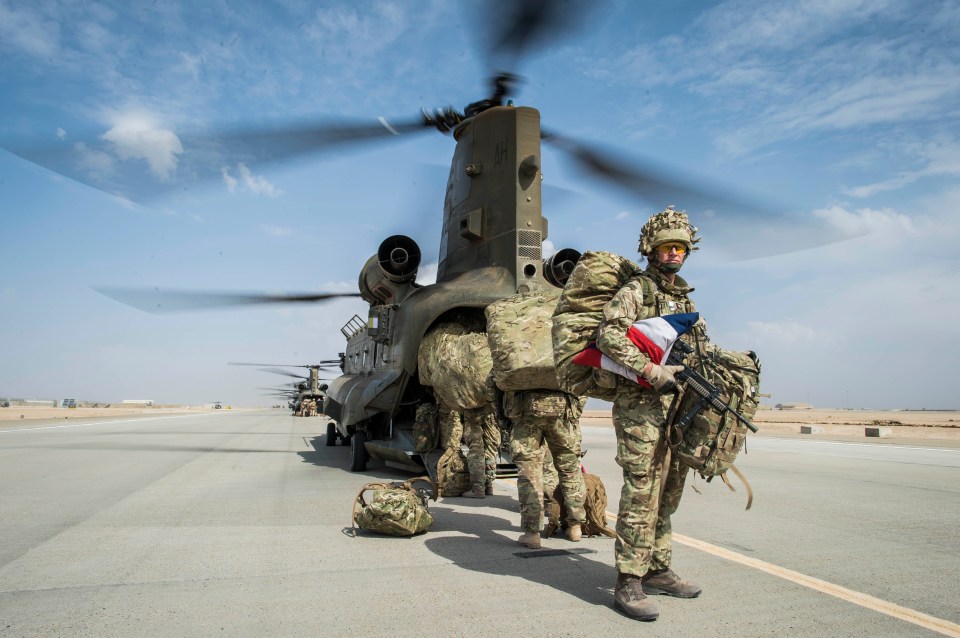 Wing Commander Matt Radnall, Officer Commanding 7 Force Protection Wing, carries a carefully folded Union Flag under his arm and back home to the UK as he prepares to board the last Chinook helicopter as the very last British boots to leave Camp Bastion, Helmand Province, Afghanistan, as UK and Coalition forces carry out their Tactical Withdrawal finally leaving the base and handing it over to Afghan National Army. PRESS ASSOCIATION Photo. Picture date: Monday October 27, 2014. See PA story DEFENCE Afghanistan. Photo credit should read: Ben Birchall/PA Wire