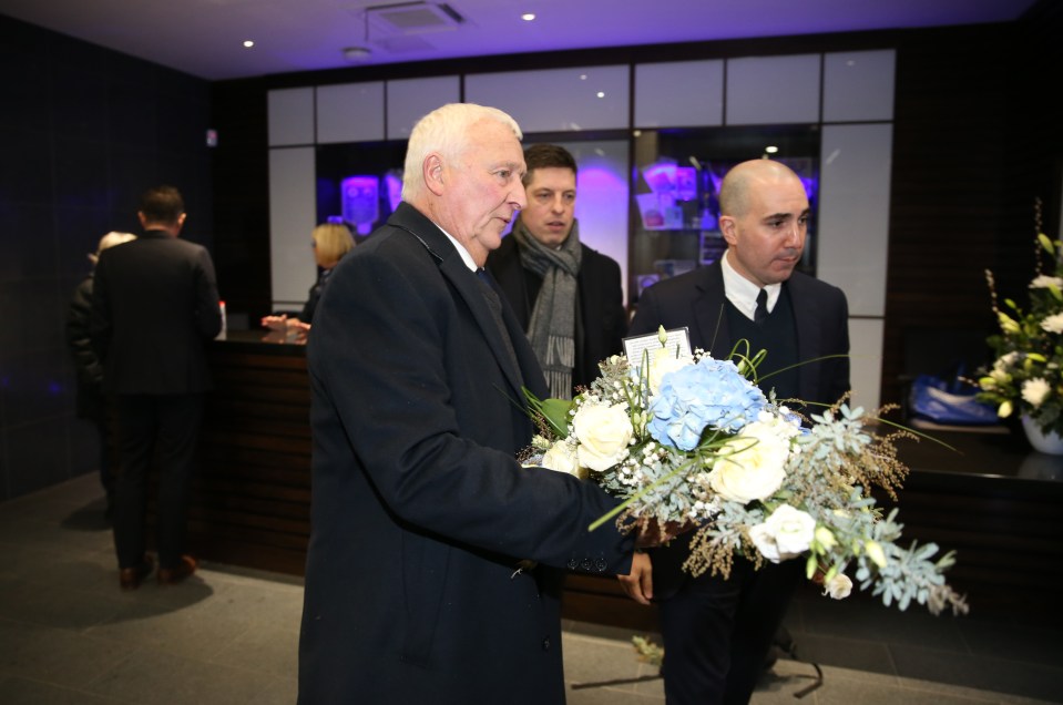 LEICESTER, ENGLAND - DECEMBER 18: Club Ambassador Mike Summerbee of Manchester City and Chief Operating Officer Omar Berrada of Manchester City lay flowers at King Power Stadium in tribute to the clubs late chairman Vichai Srivaddhanaprabha ahead of the Carabao Cup match between Leicester City and Manchester City at King Power Stadium on December 18th , 2018 in Leicester, United Kingdom.  (Photo by Plumb Images/Leicester City FC via Getty Images)