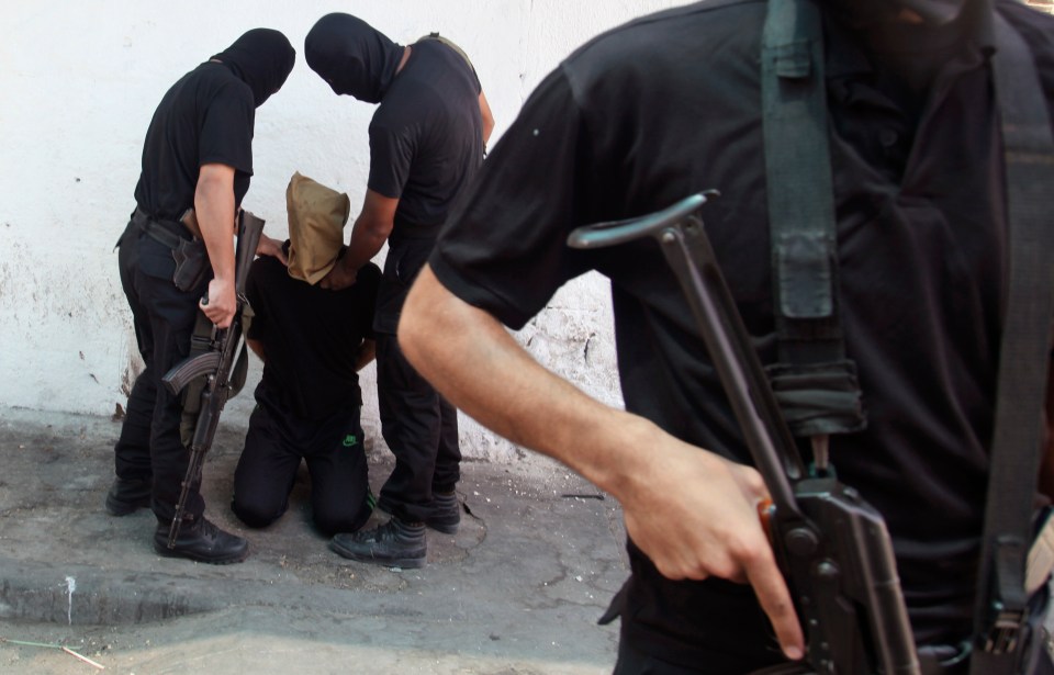 Hamas militants with a Palestinian suspected of collaborating with Israel before being executed in Gaza in August 2014. Sinwar murdered several 'collaborators' with his bare hands.