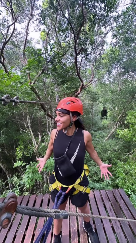 a woman wearing an orange helmet and a black tank top with the word jesus on it