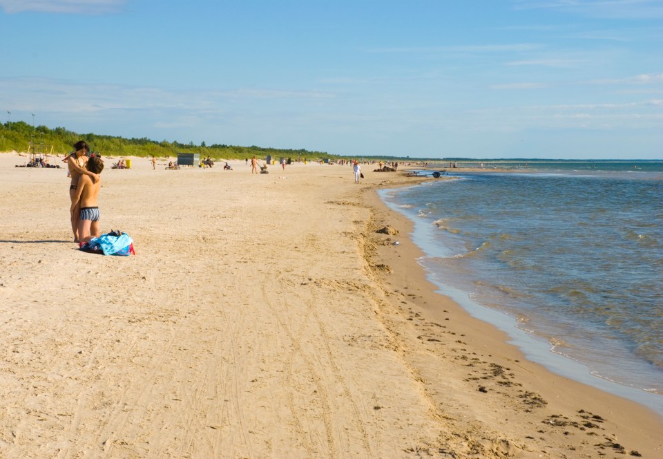 The beach has soft white sands and people search for amber in the sea