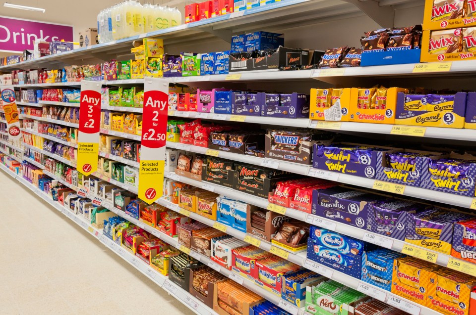 a candy aisle in a store with a sign that says any 2 for 1.50