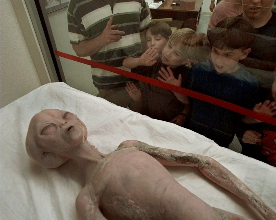 Children eye a model of an alien on display inside the International UFO Museum and Research Center in Roswell