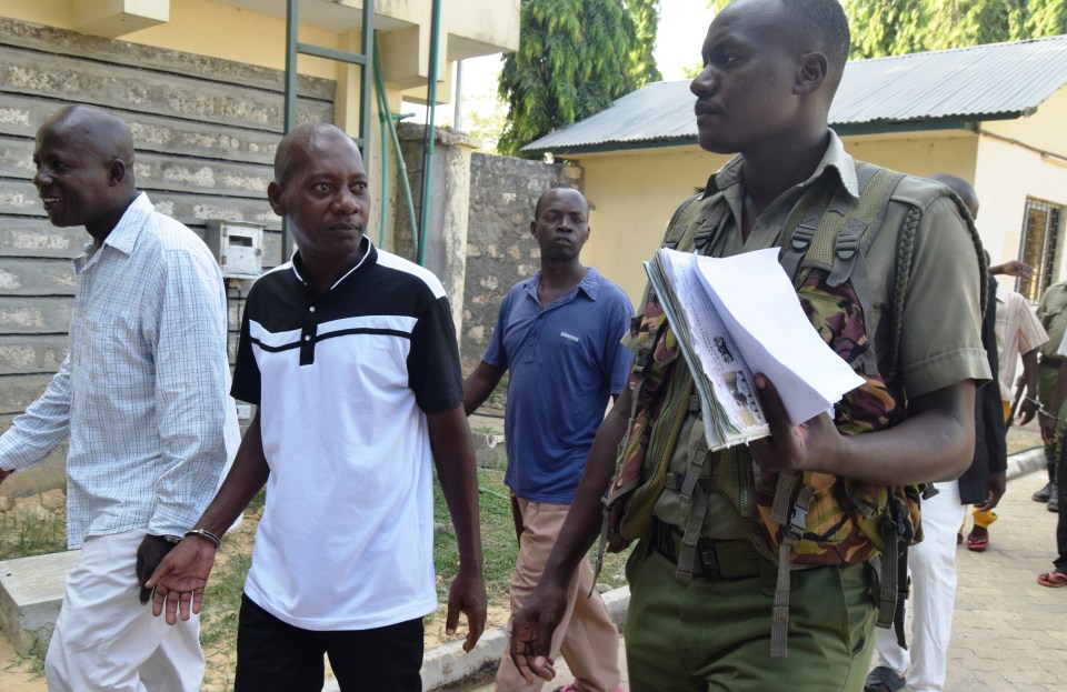 Cult preacher Mackenzie, second left, arrives at the Shazu Law Courts in Mombasa