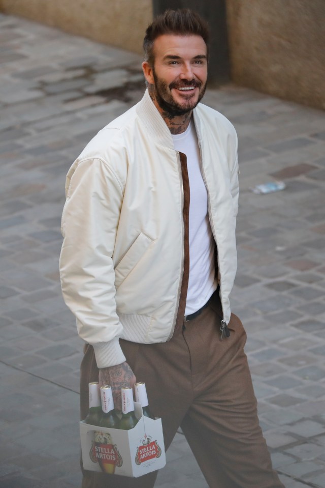 David Beckham flashed a beaming smile as he carried a six-pack of Stella Artois in Barcelona