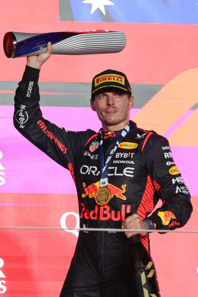 a man in a red bull outfit holds up a trophy