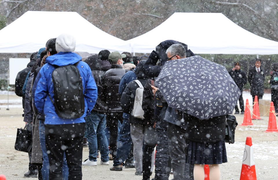 People line up under snowfall for hearing tickets before the verdict in the Kyoto animation arson and murder case