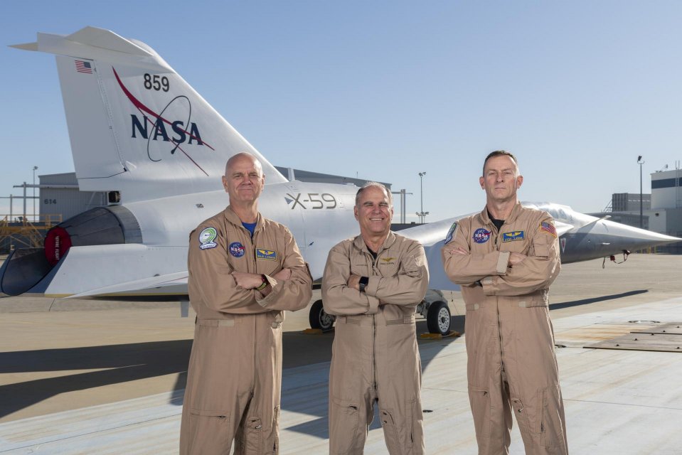 Test pilots Nils Larson (L), Dan 'Dog' Canin (C) and Jim 'Clue' Less (R) pose with the newly-painted X-59 at Lockheed Martin Skunk Works in Palmdale, California